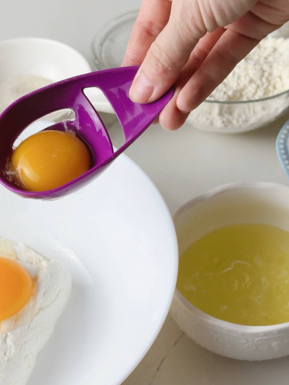 Egg yolks being separated from egg whites in a bowl.