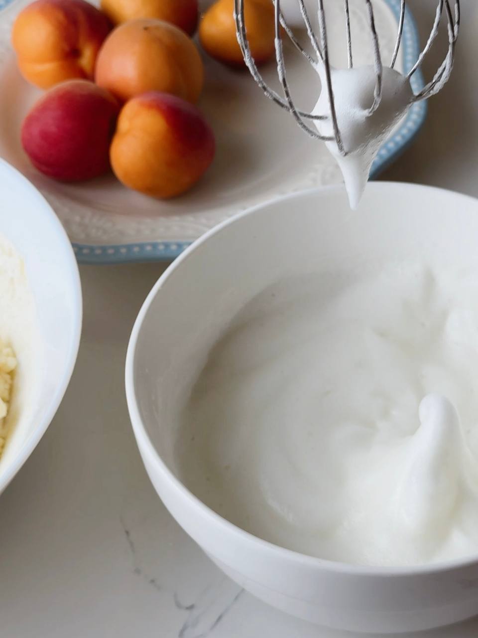 Egg whites whipped to soft peaks in a clean mixing bowl