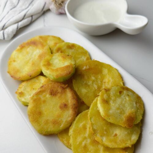 Crispy zucchini rounds served with dipping sauce – golden, crunchy, and ready to enjoy.
