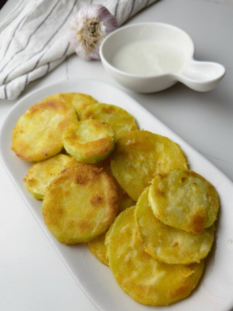 Crispy zucchini rounds served with dipping sauce – golden, crunchy, and ready to enjoy.