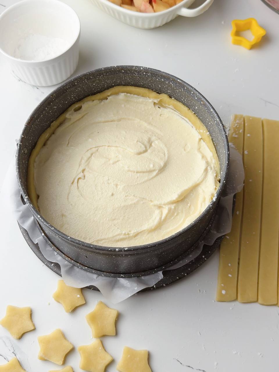Assembling the peach pie with mascarpone, peach slices, and star decorations