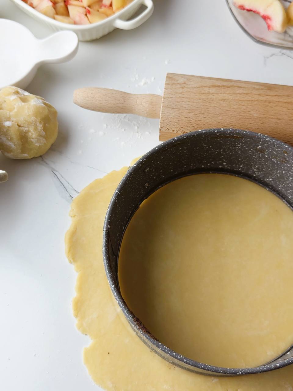 Evenly rolled dough forming the base of the peach pie