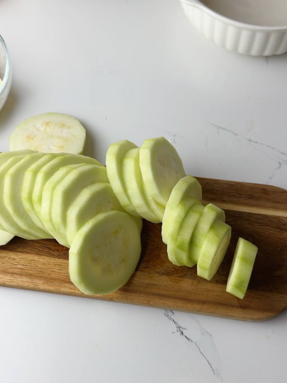 Fresh zucchini sliced into even, round pieces, ready for coating.