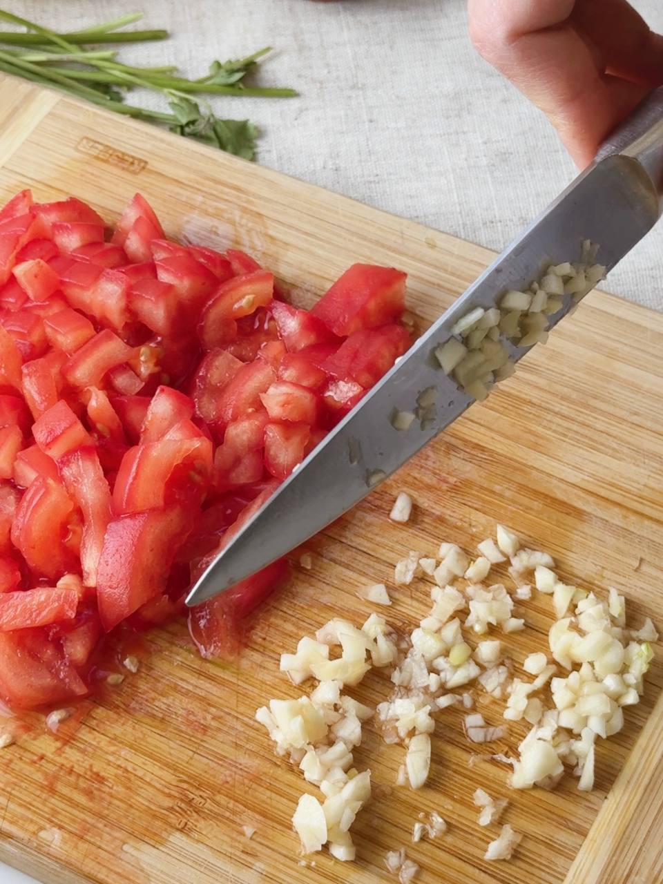 Diced and peeled tomatoes and chopped garlic prepared for red lentil coconut soup.