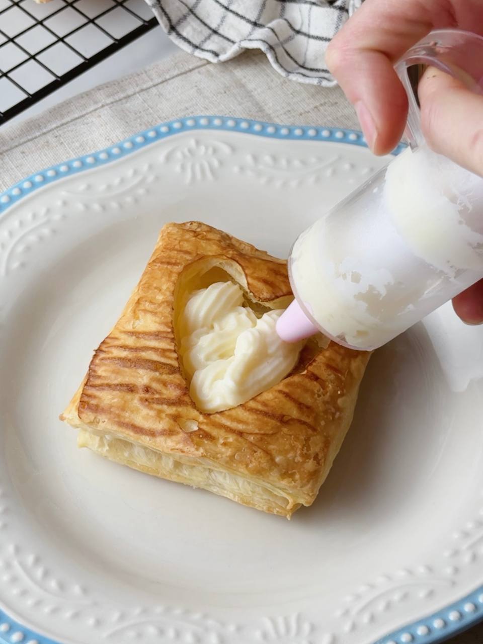 Filling baked puff pastry with custard using syringe
