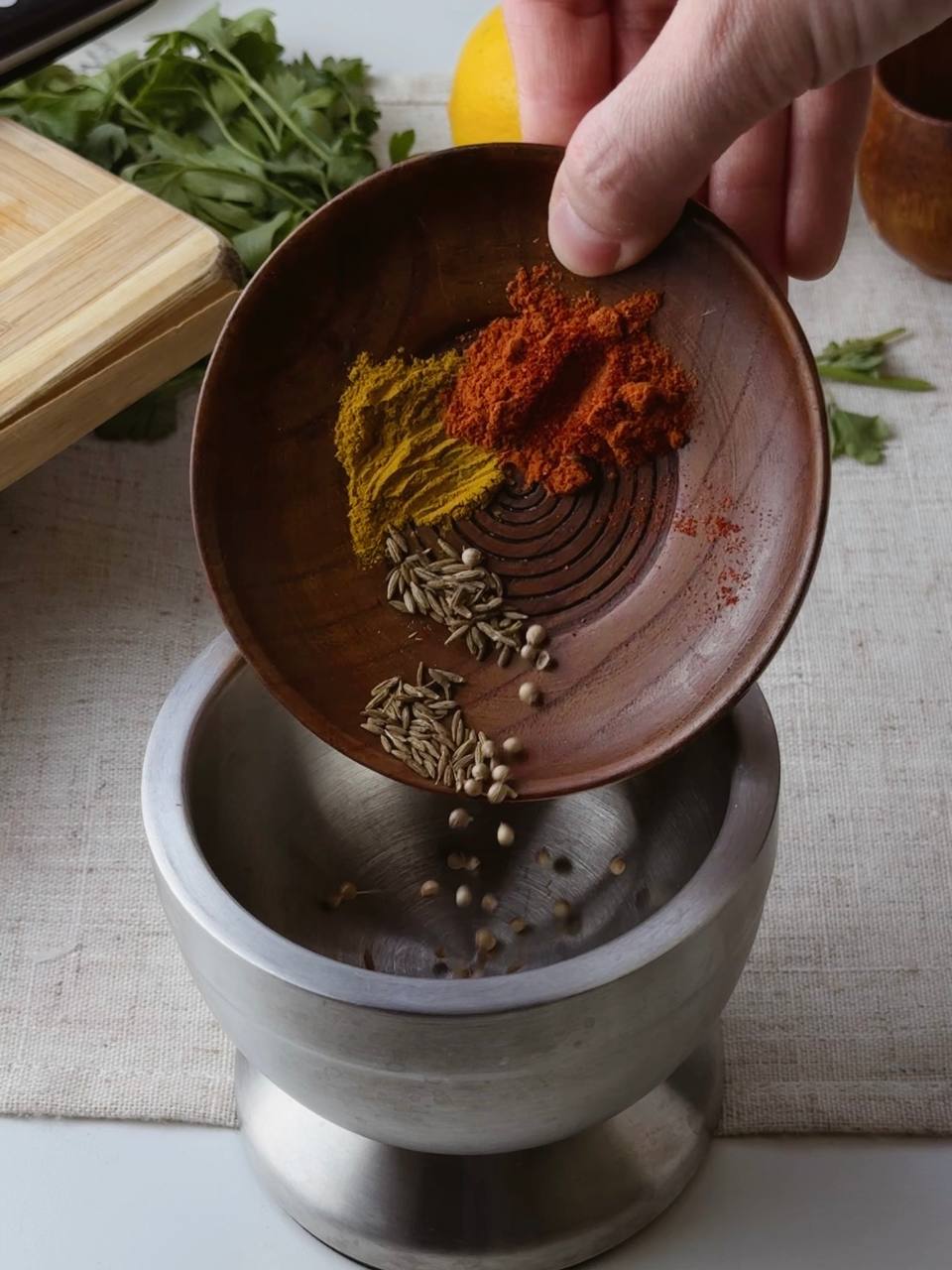 Grinding aromatic spices — cumin, coriander, turmeric, and paprika — for red lentil soup.