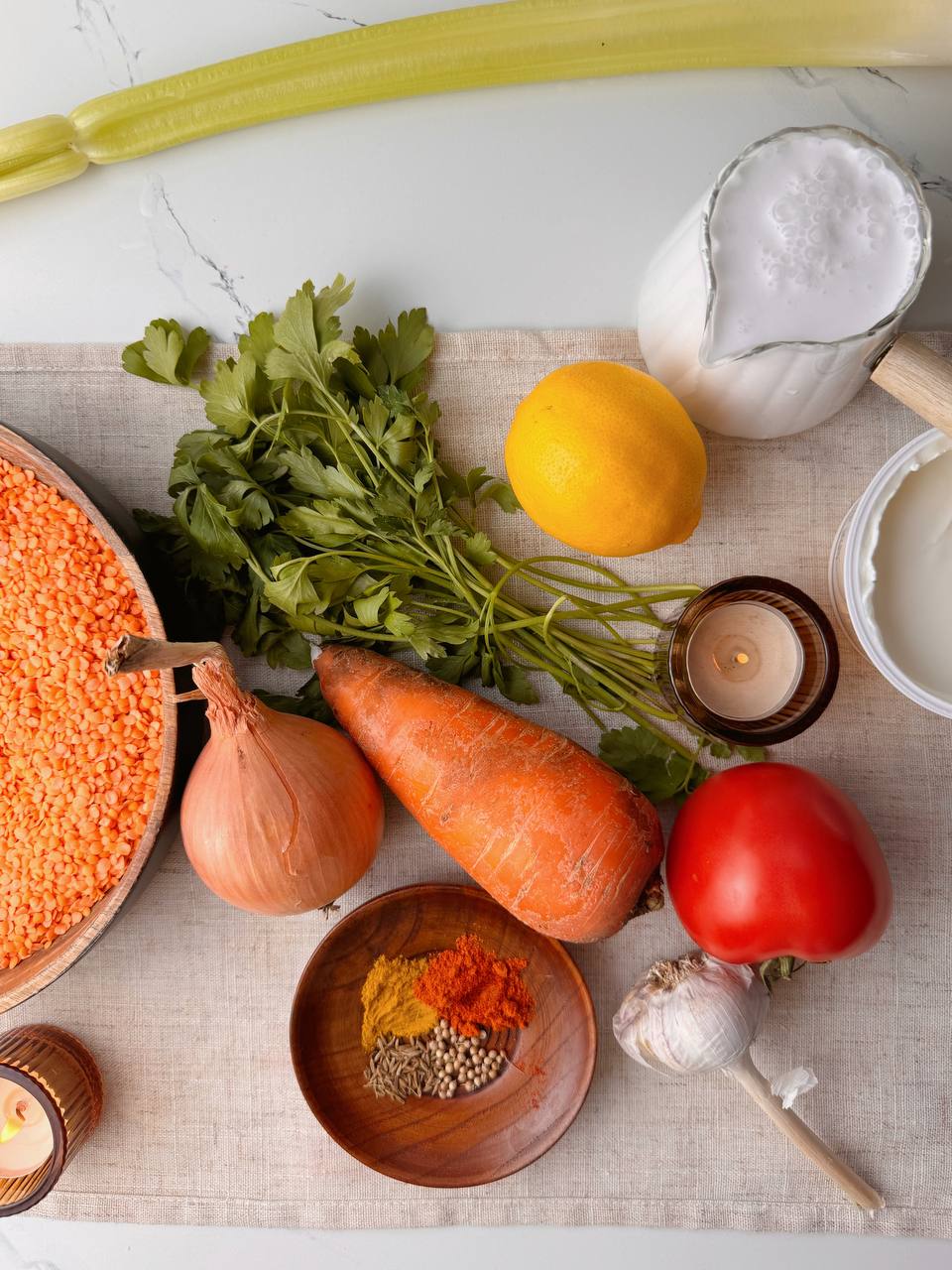 Ingredients for red lentil soup with coconut milk — vegetables, spices, and lentils on a kitchen counter