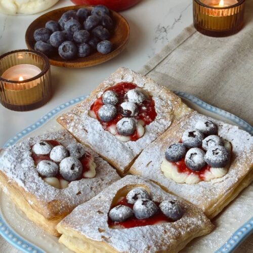 Served puff pastry hearts dessert with berries and custard