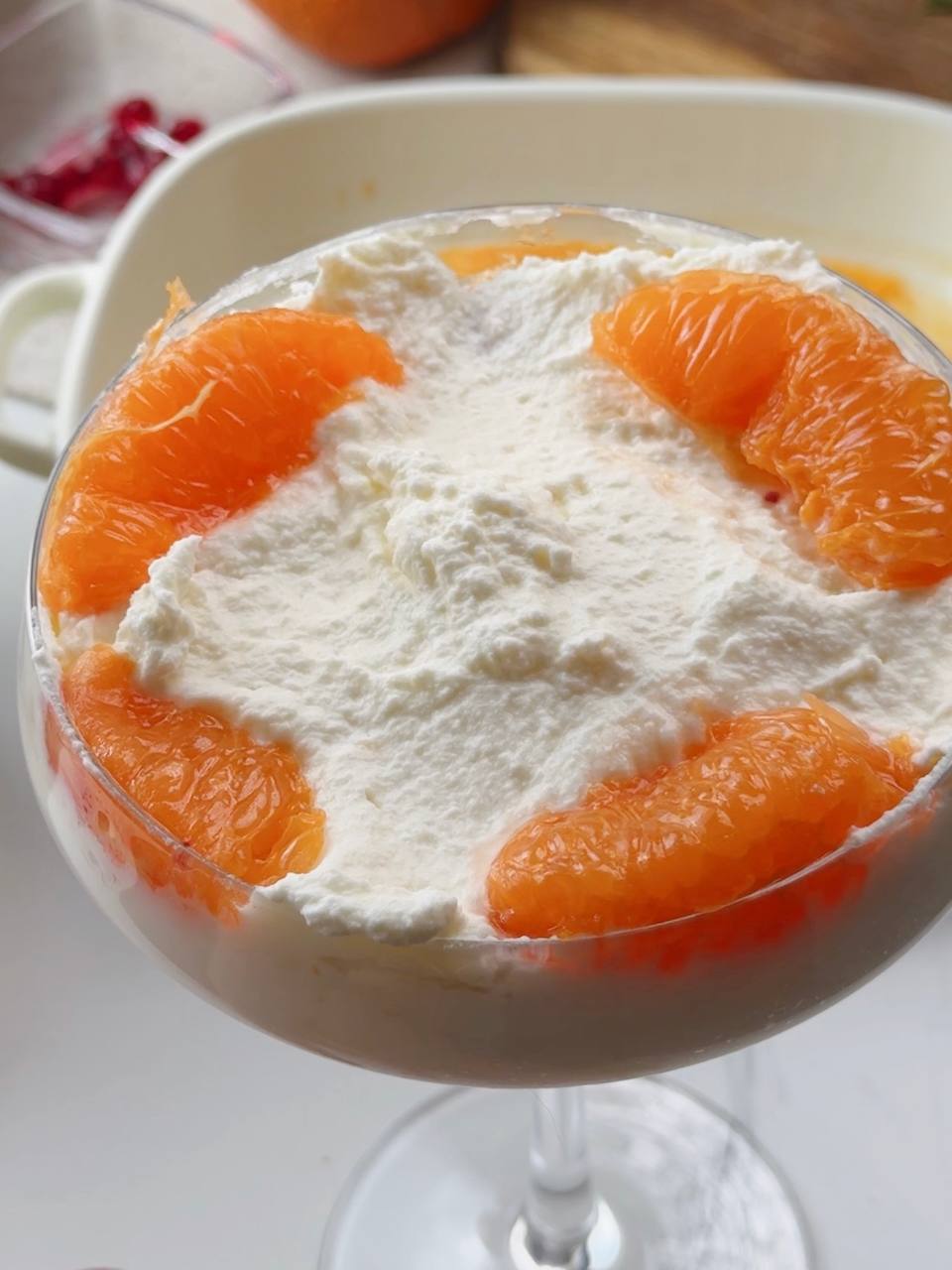 Adding fresh clementine segments to tiramisu layers