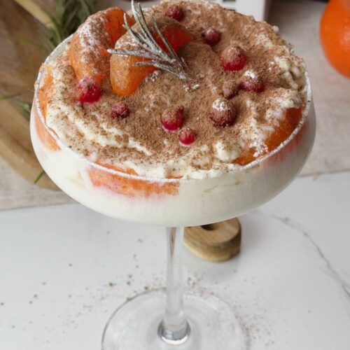 No-bake clementine tiramisu decorated with cocoa and cranberries