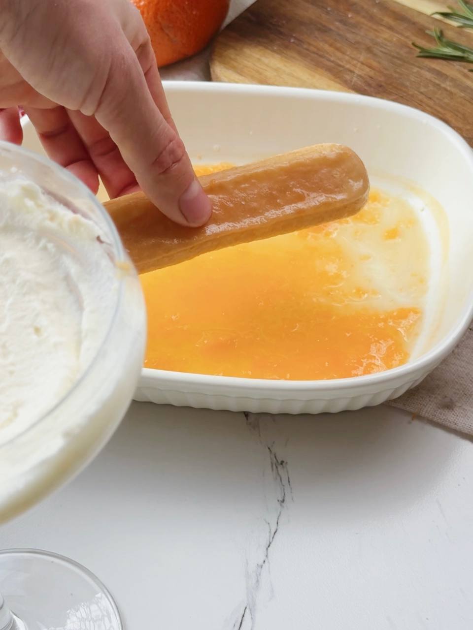 Dipping ladyfinger cookies in clementine juice