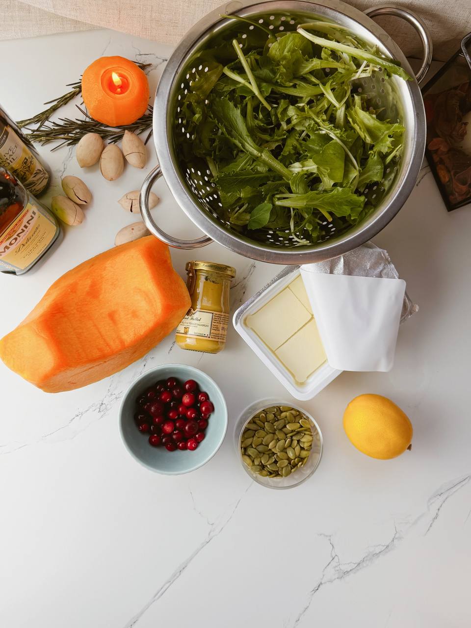Ingredients for baked pumpkin salad with feta, cranberries, pecans, pumpkin seeds, and mixed greens