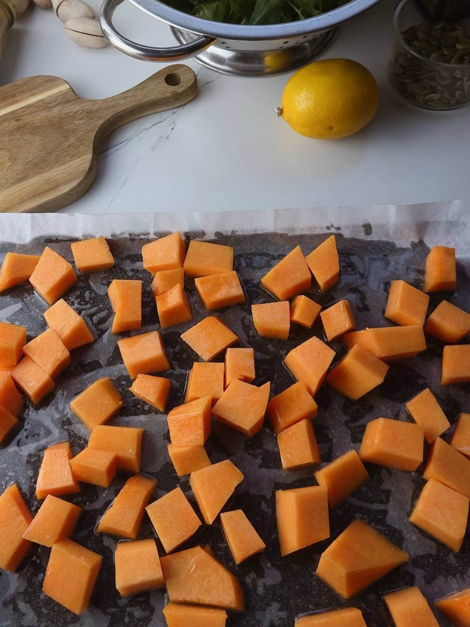 Cubed pumpkin on oven tray before baking for healthy pumpkin salad with feta