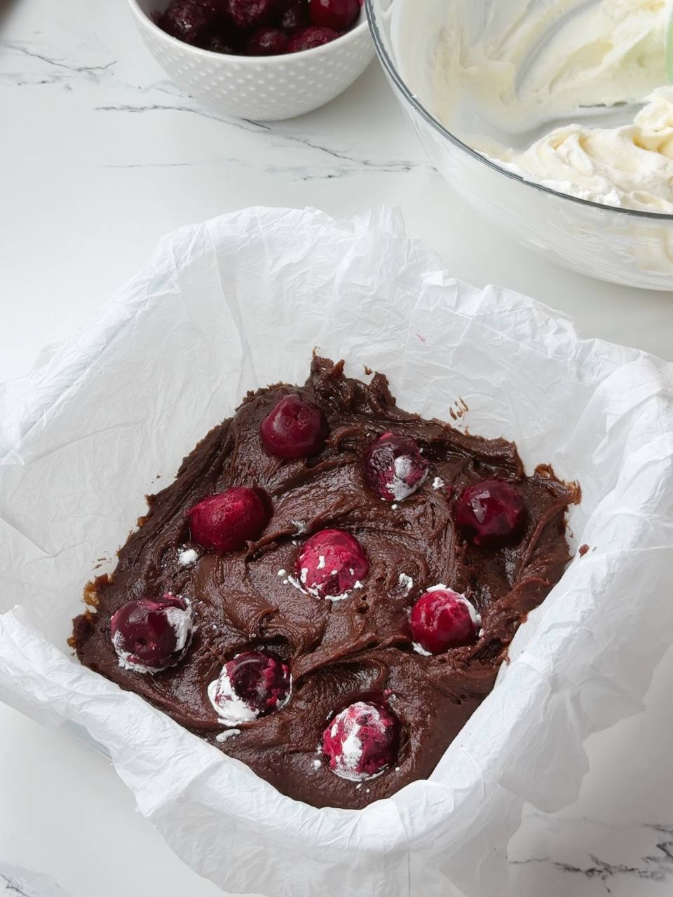 Chocolate brownie base with cherries in pan