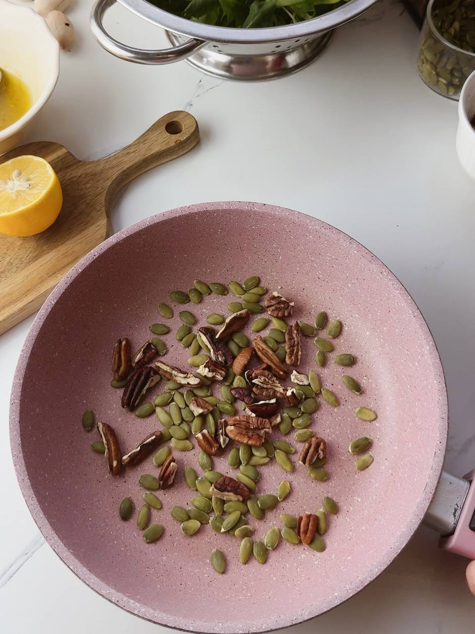 Toasting pecans and pumpkin seeds in a dry pan for crunchy salad topping