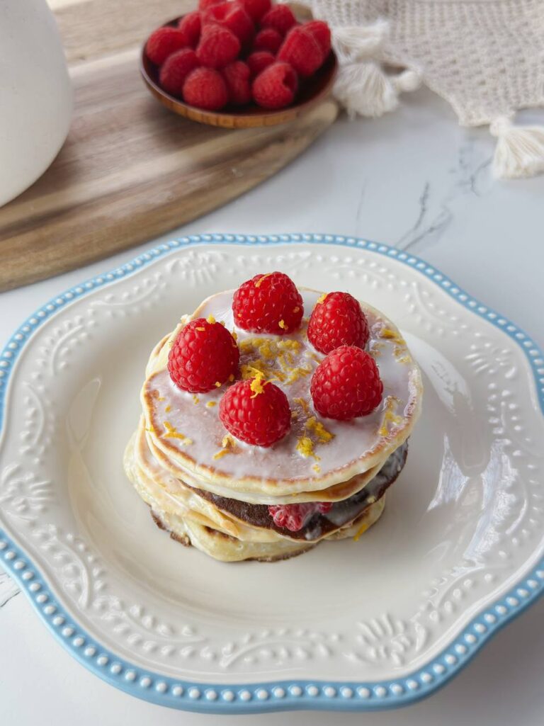 Close-up of lemon yogurt pancakes with raspberries and creamy topping