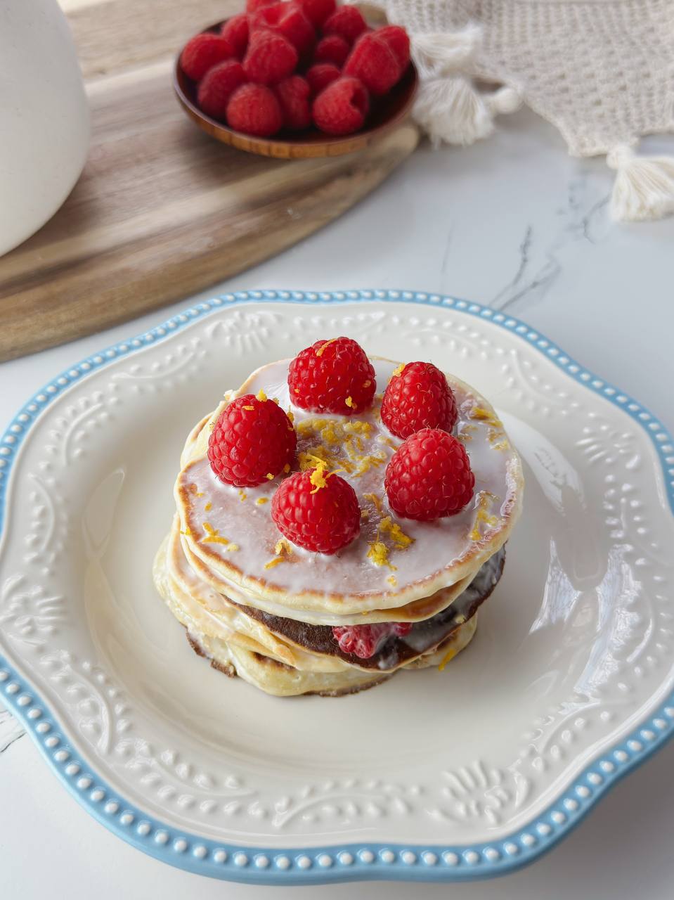 Close-up of lemon yogurt pancakes with raspberries and creamy topping