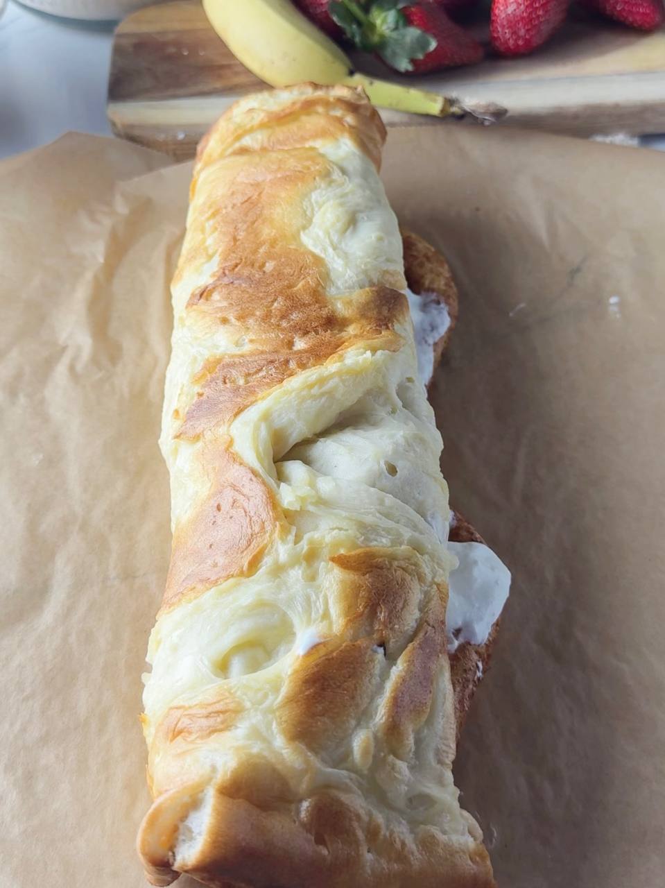 Assembled strawberry pancake roll wrapped before chilling