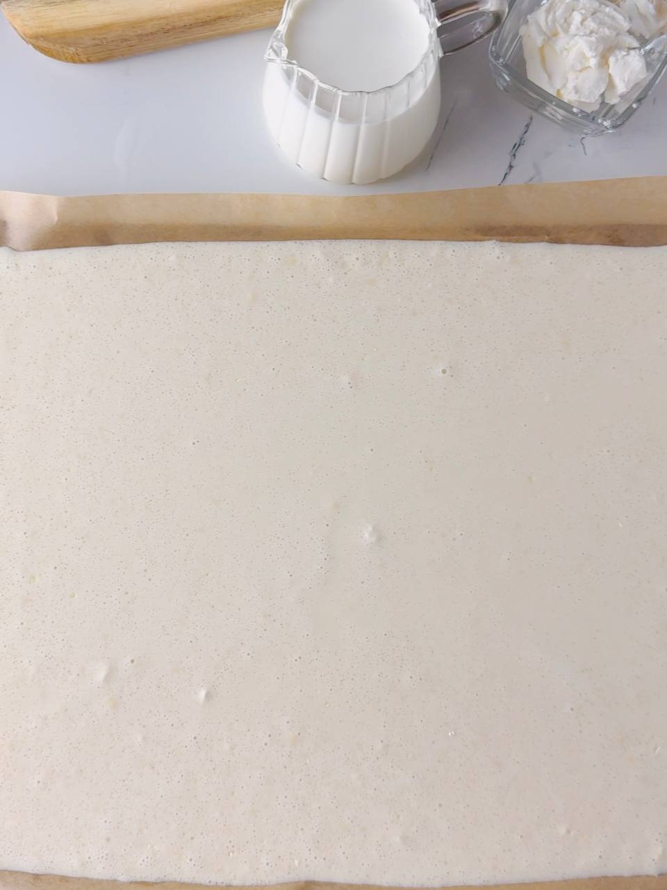 Evenly spread pancake batter on baking tray before baking in oven