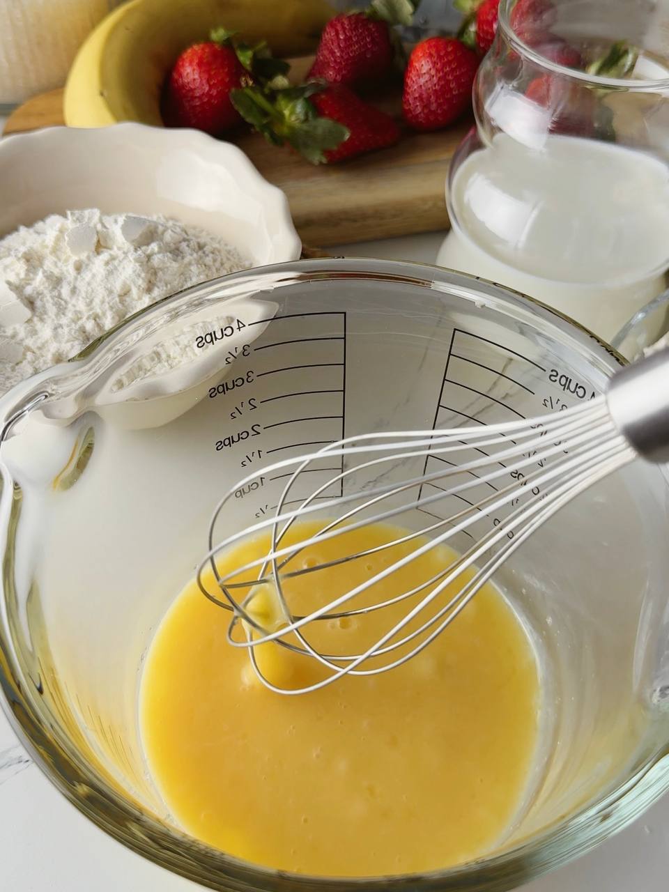 Whisking eggs and sugar to make batter for oven baked pancake