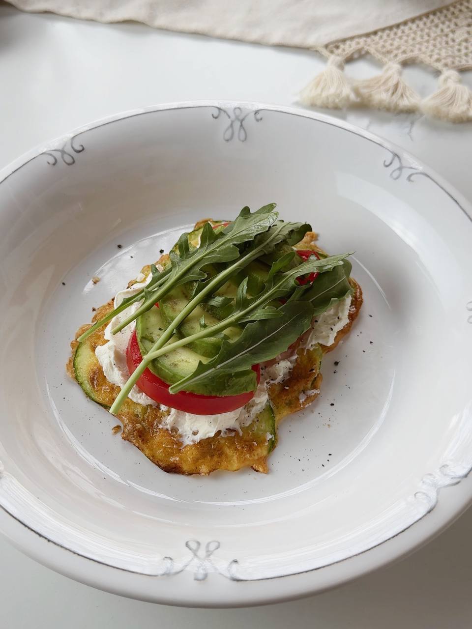 adding avocado slices and arugula to zucchini sandwich filling