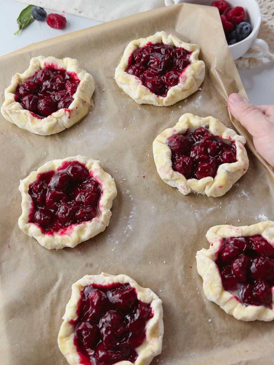Unbaked cherry galettes with cottage cheese dough ready for oven