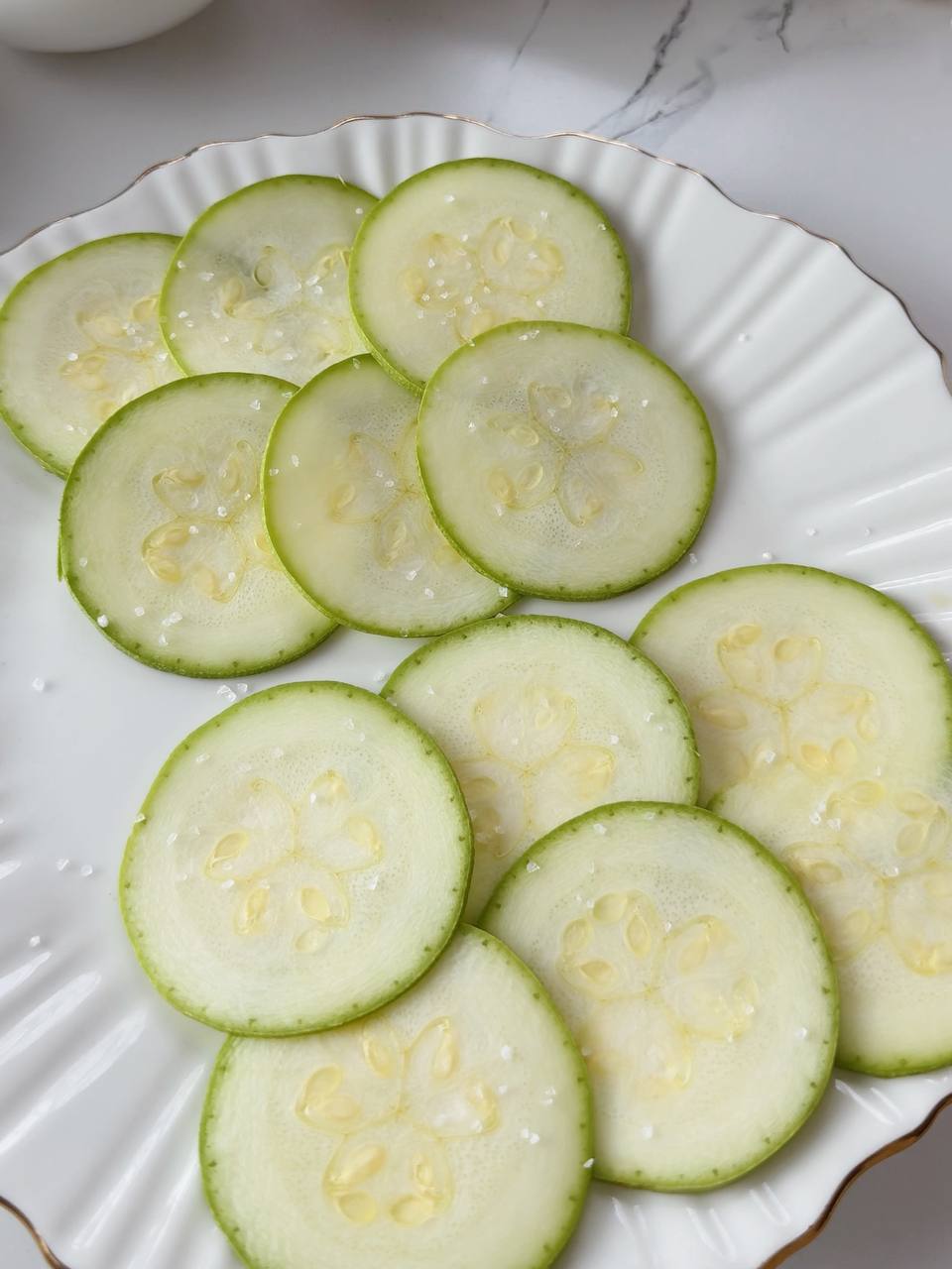 thinly sliced zucchini rounds sprinkled with salt for baking