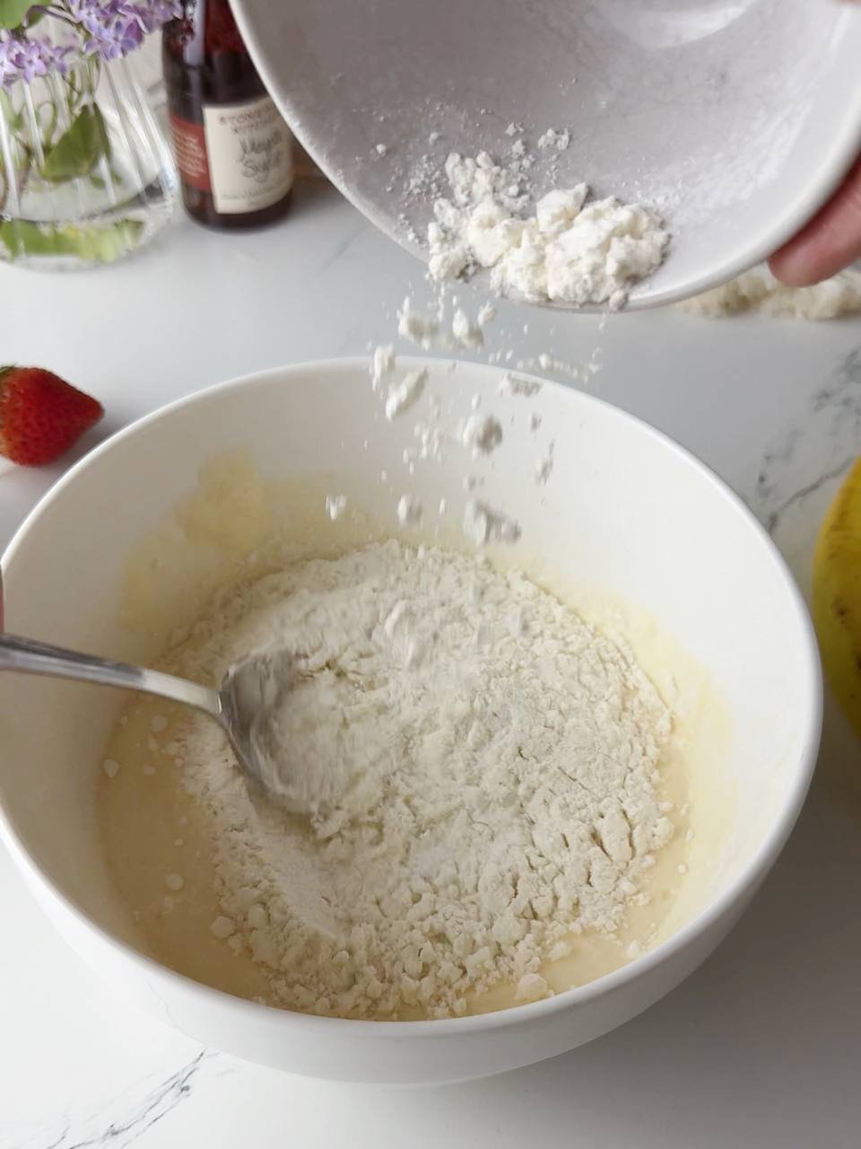 adding flour to pancake batter with yogurt and egg