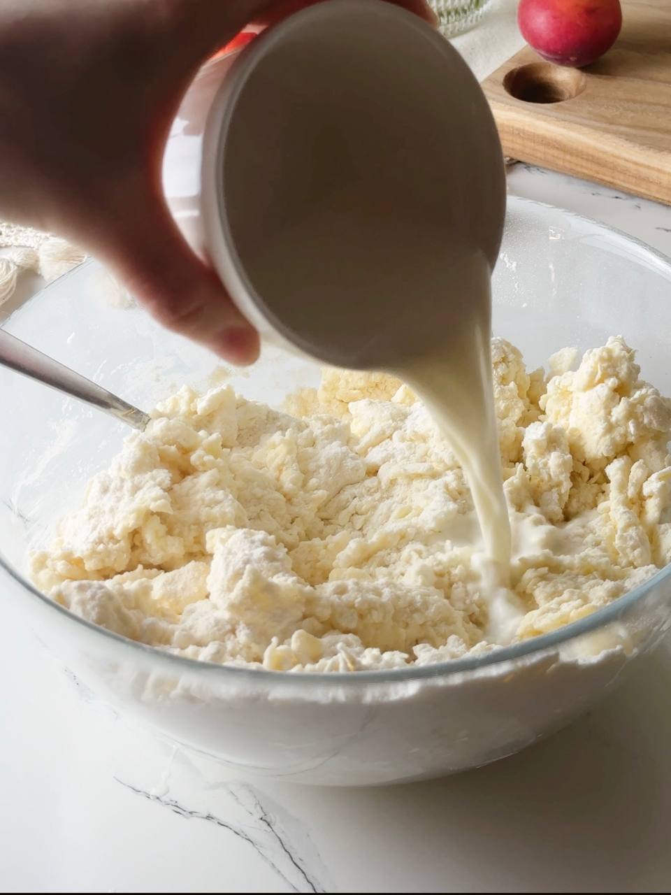 pouring milk into the scone dough mixture