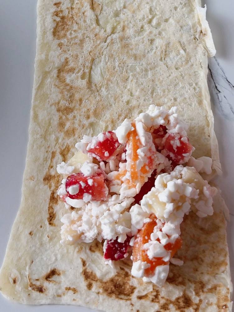 placing cottage cheese and fruit filling on a lavash strip