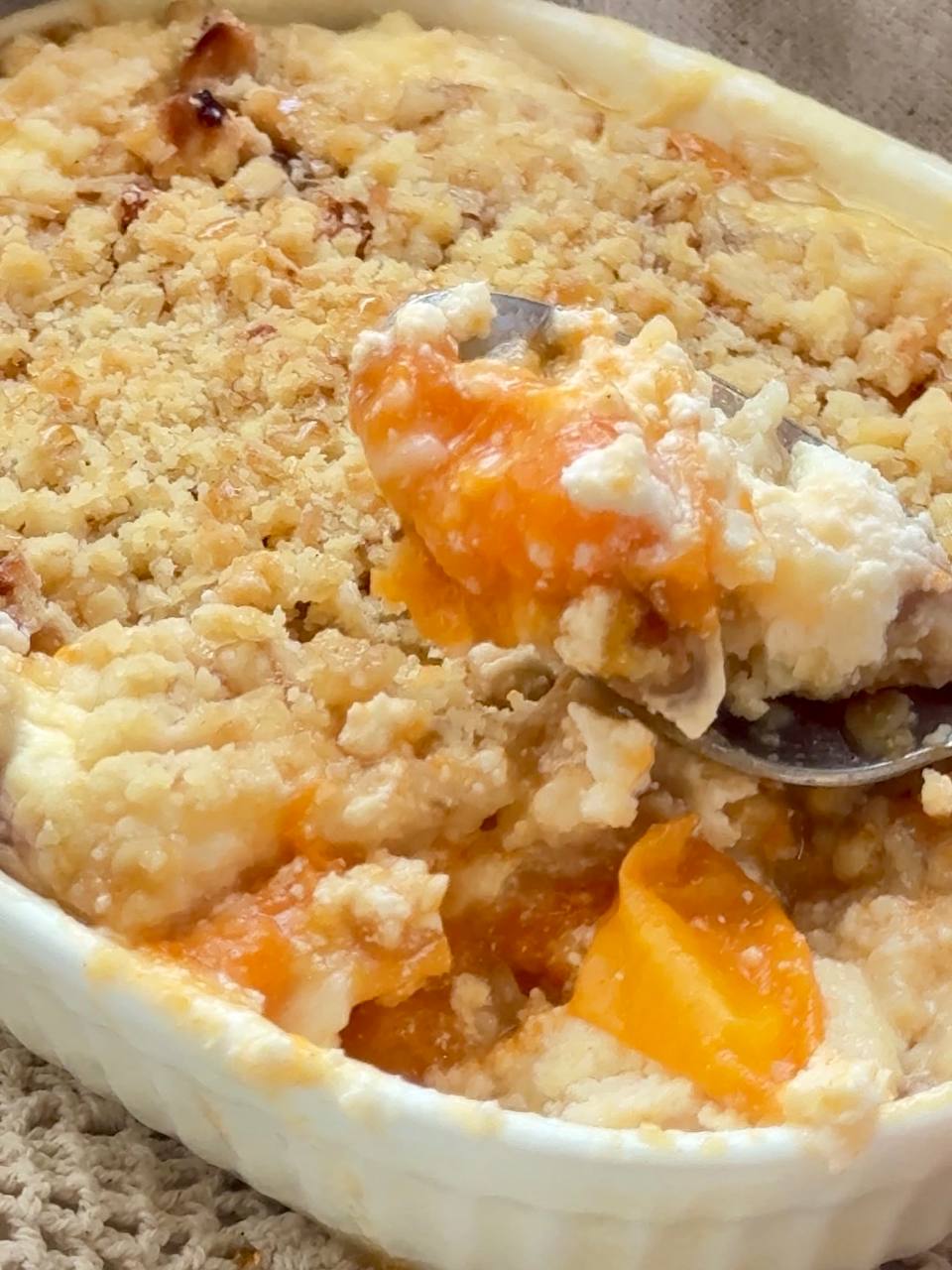 spoonful of apricot cottage cheese crumble with creamy filling