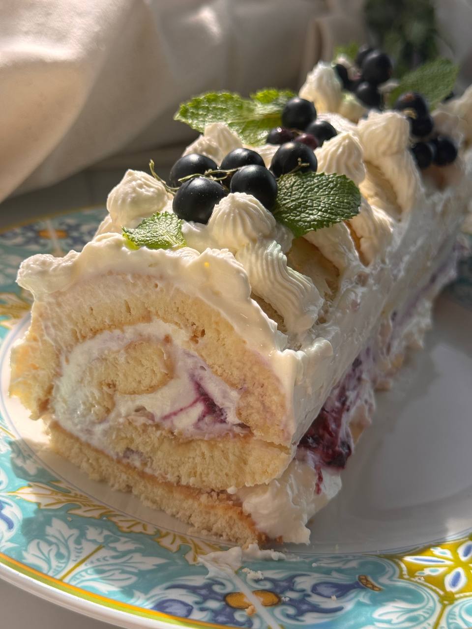 berry roll cake with cottage cheese cream and blackcurrants