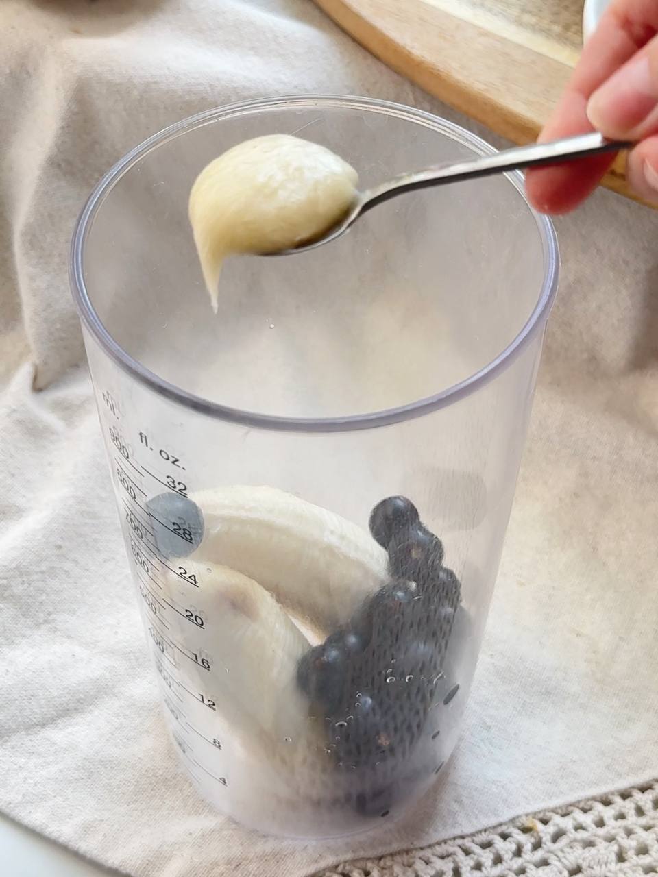 blackcurrants, banana, and honey in a blender cup