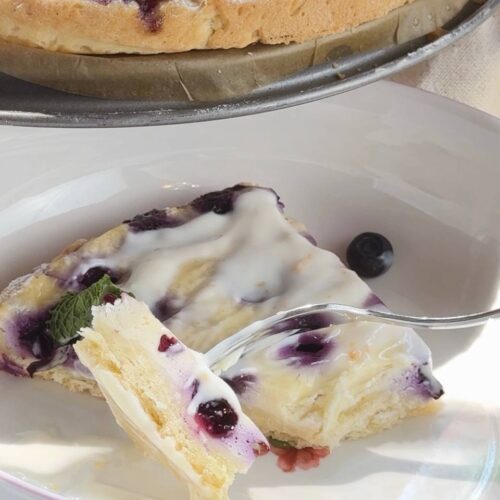 slice of blueberry cottage cheese pie served with lemon cream sauce