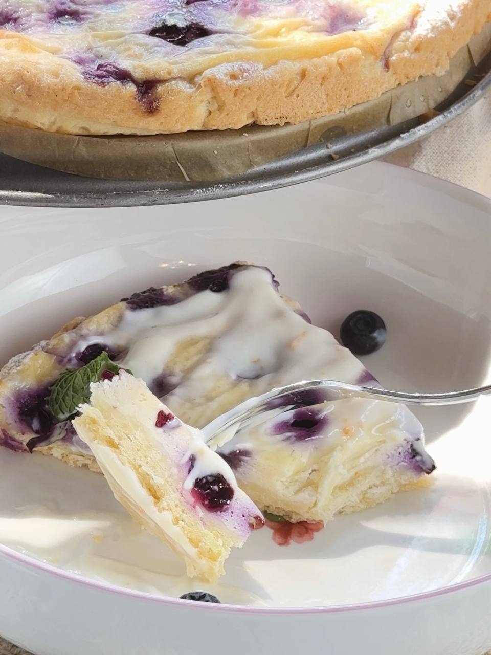 slice of blueberry cottage cheese pie served with lemon cream sauce