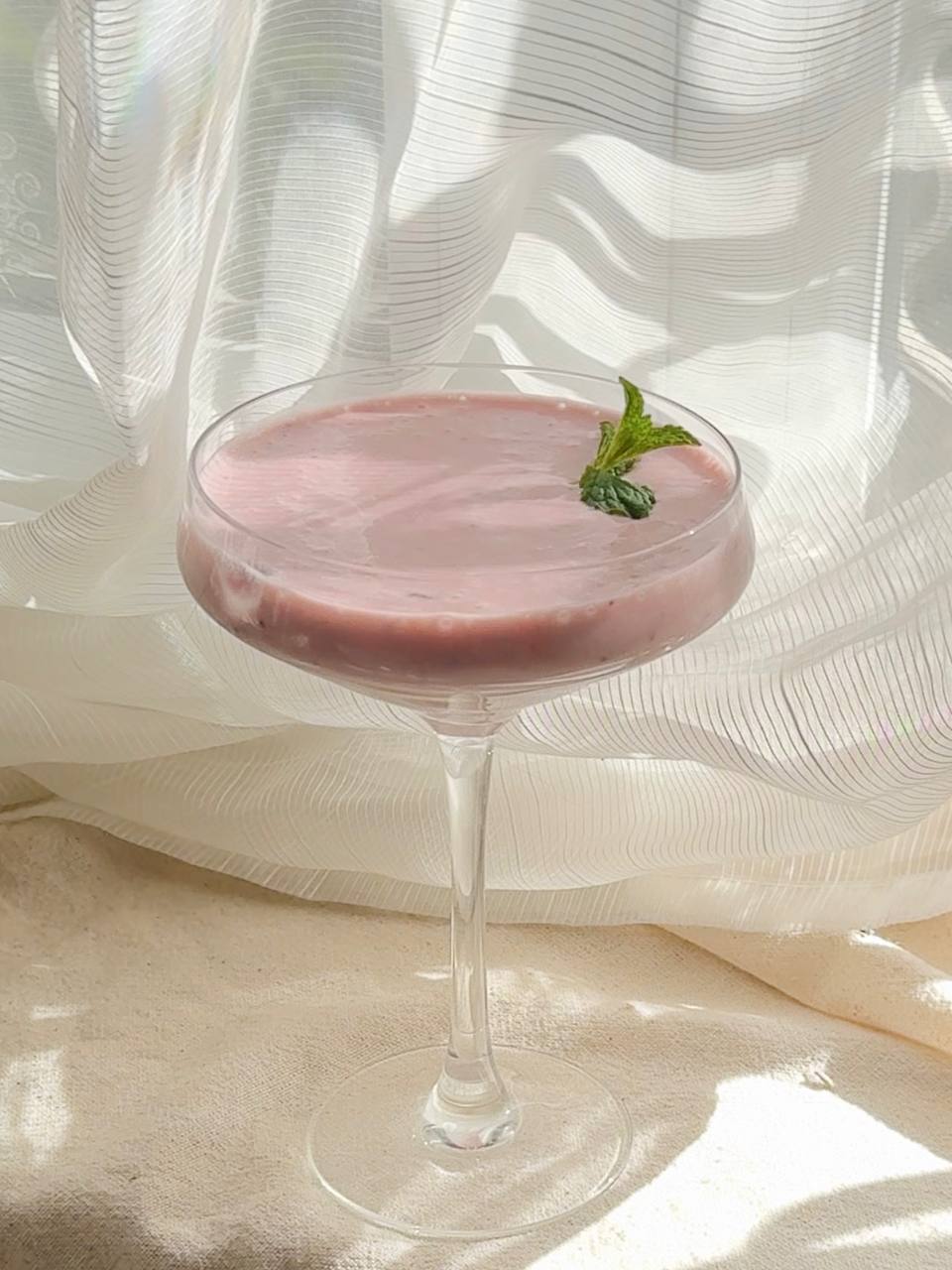 garnishing the smoothie with fresh mint