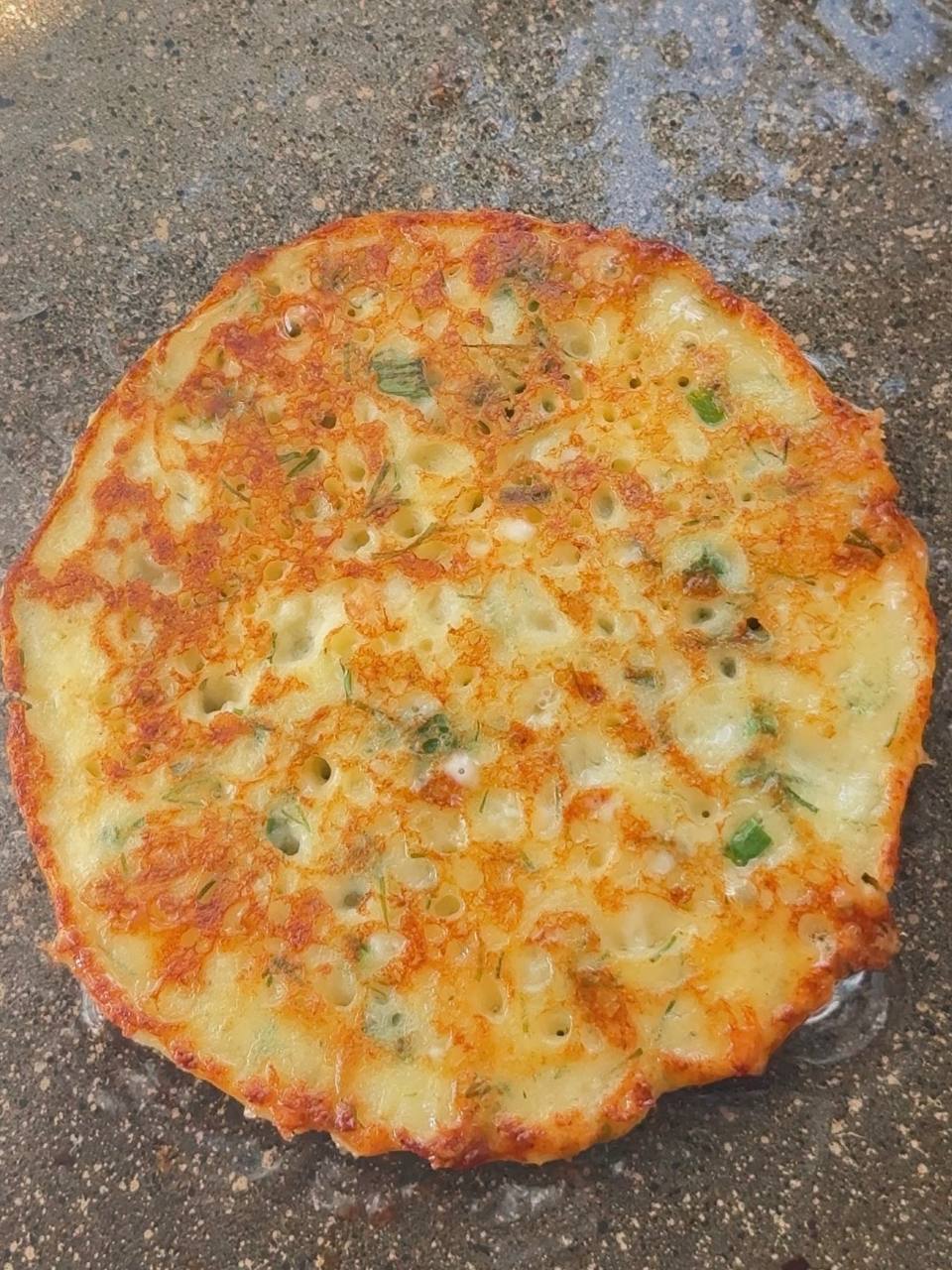 golden cottage cheese fritters cooking on the second side