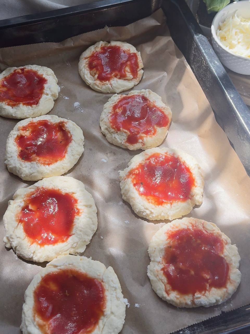 mini pizza rounds topped with tomato sauce