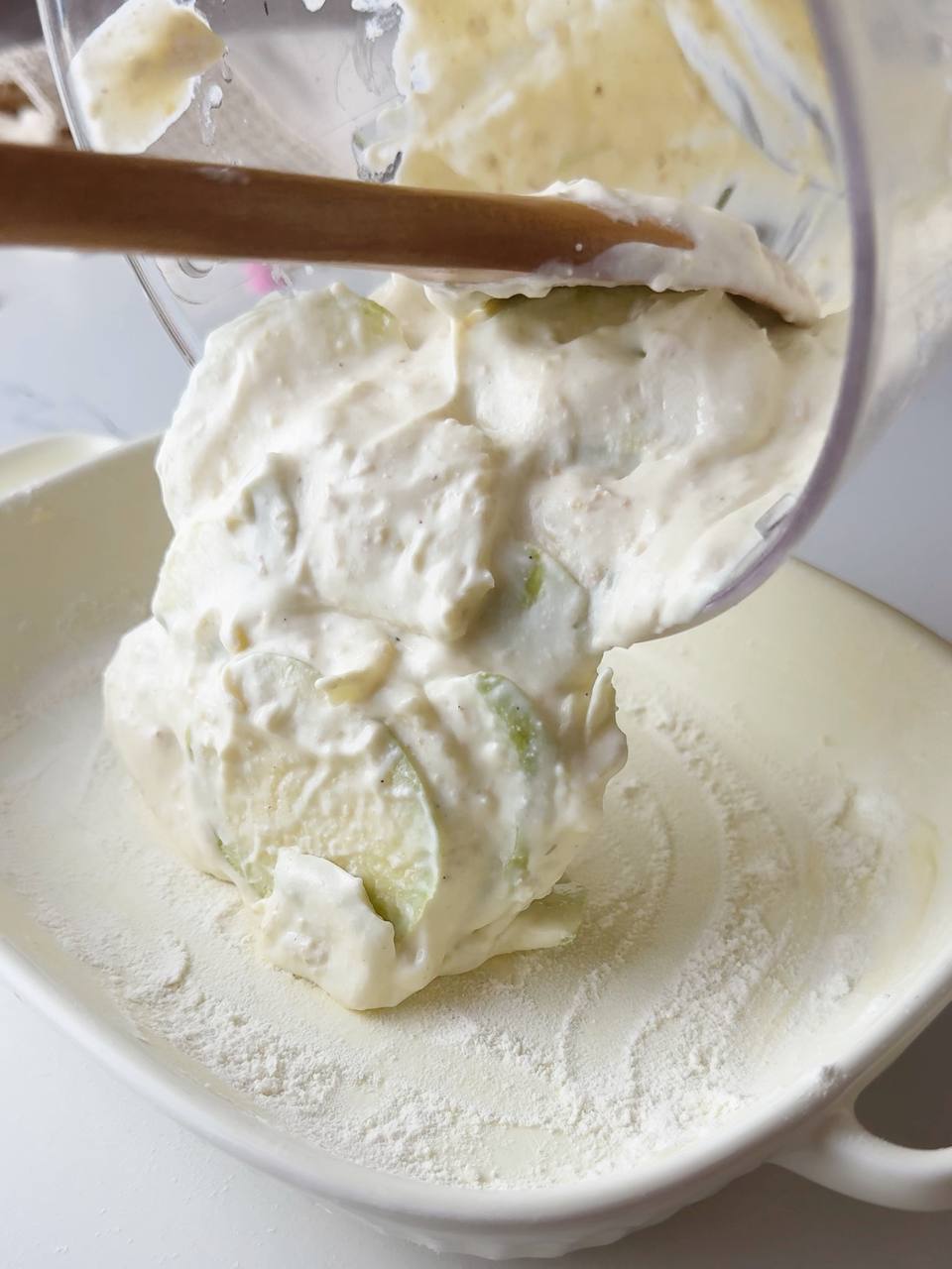 pouring apple cottage cheese oatmeal bake mixture into a prepared baking dish