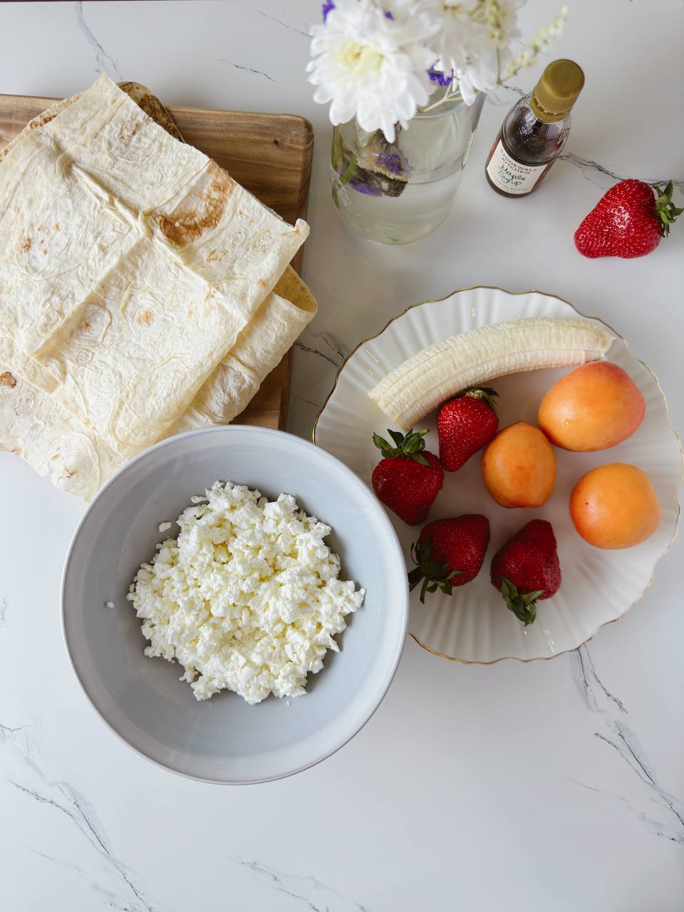 ingredients for sweet cottage cheese breakfast wraps with strawberries, banana, and apricots