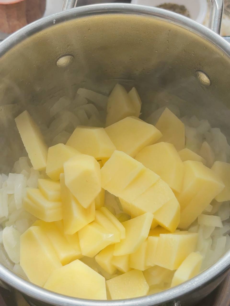 adding diced potatoes to the saucepan