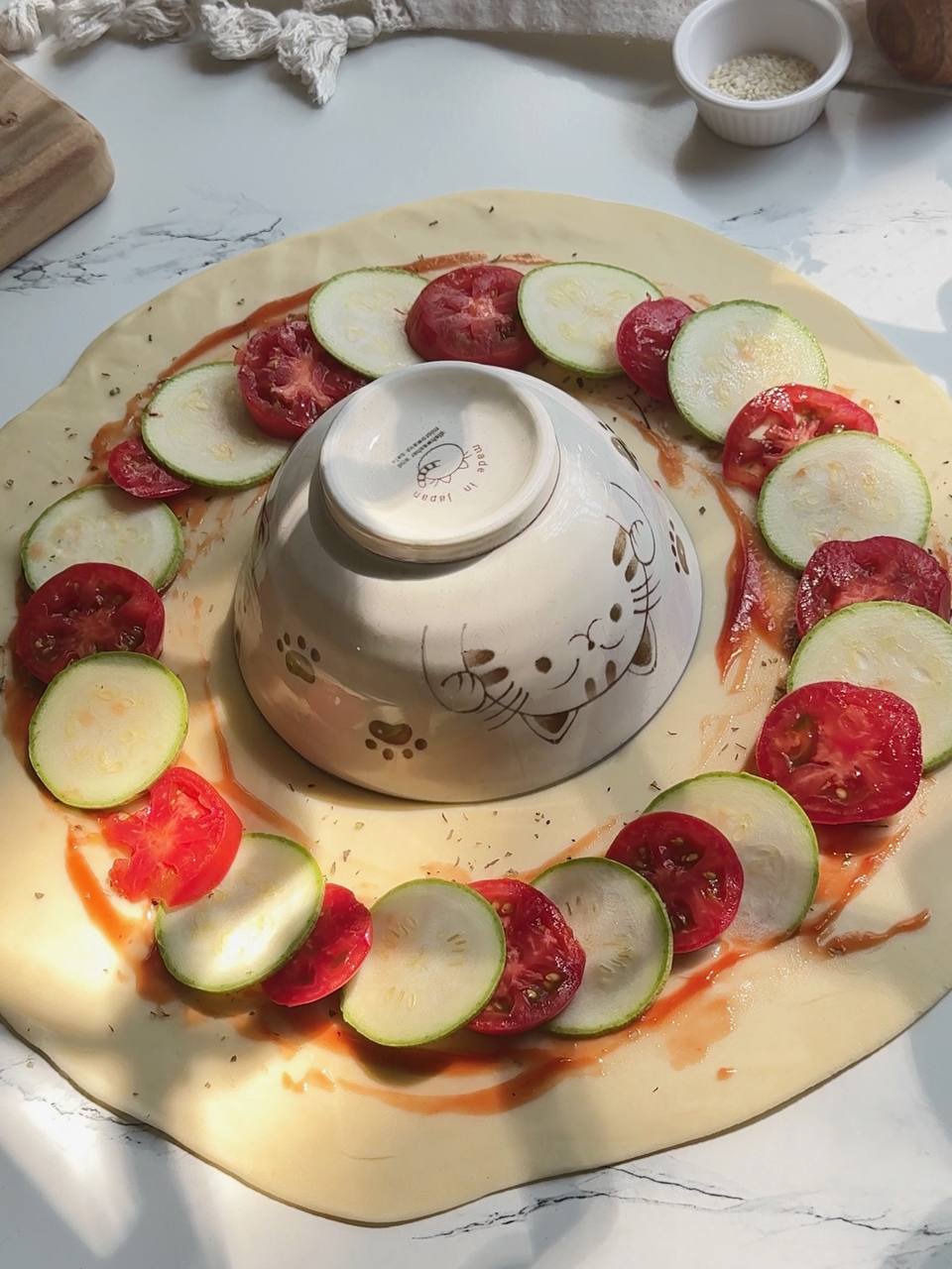 arranging zucchini and tomato slices on puff pastry