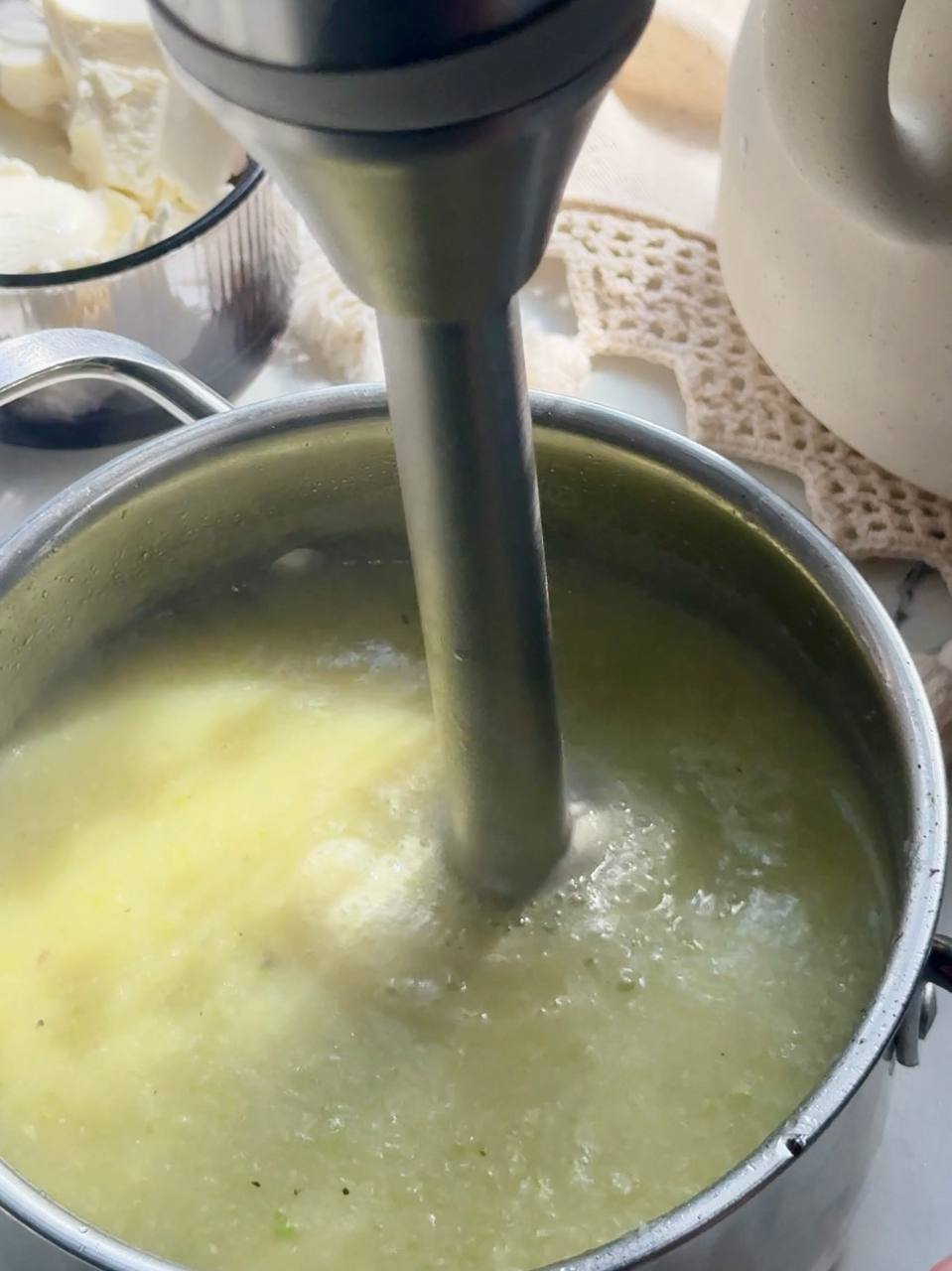 blending the zucchini soup with an immersion blender until smooth