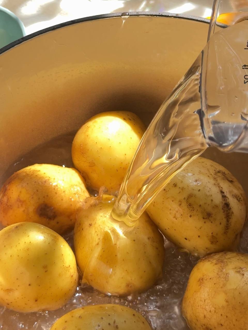 adding water to a pot of young potatoes before boiling