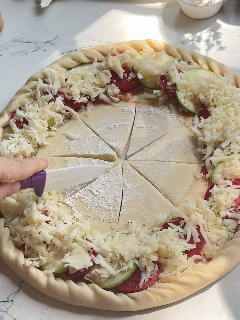 folding the pastry edge to shape a zucchini puff pastry tart