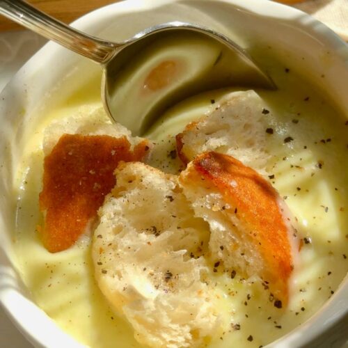 close-up of creamy zucchini soup with garlic croutons