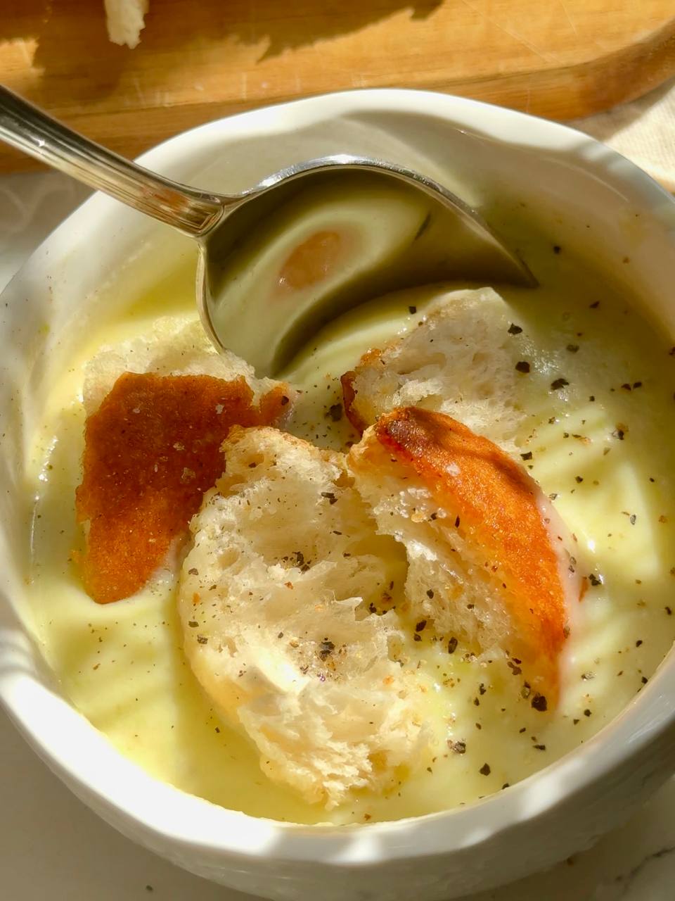 close-up of creamy zucchini soup with garlic croutons