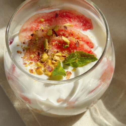 no-bake peach cheesecake cups topped with fresh peaches, pistachios, and mint
