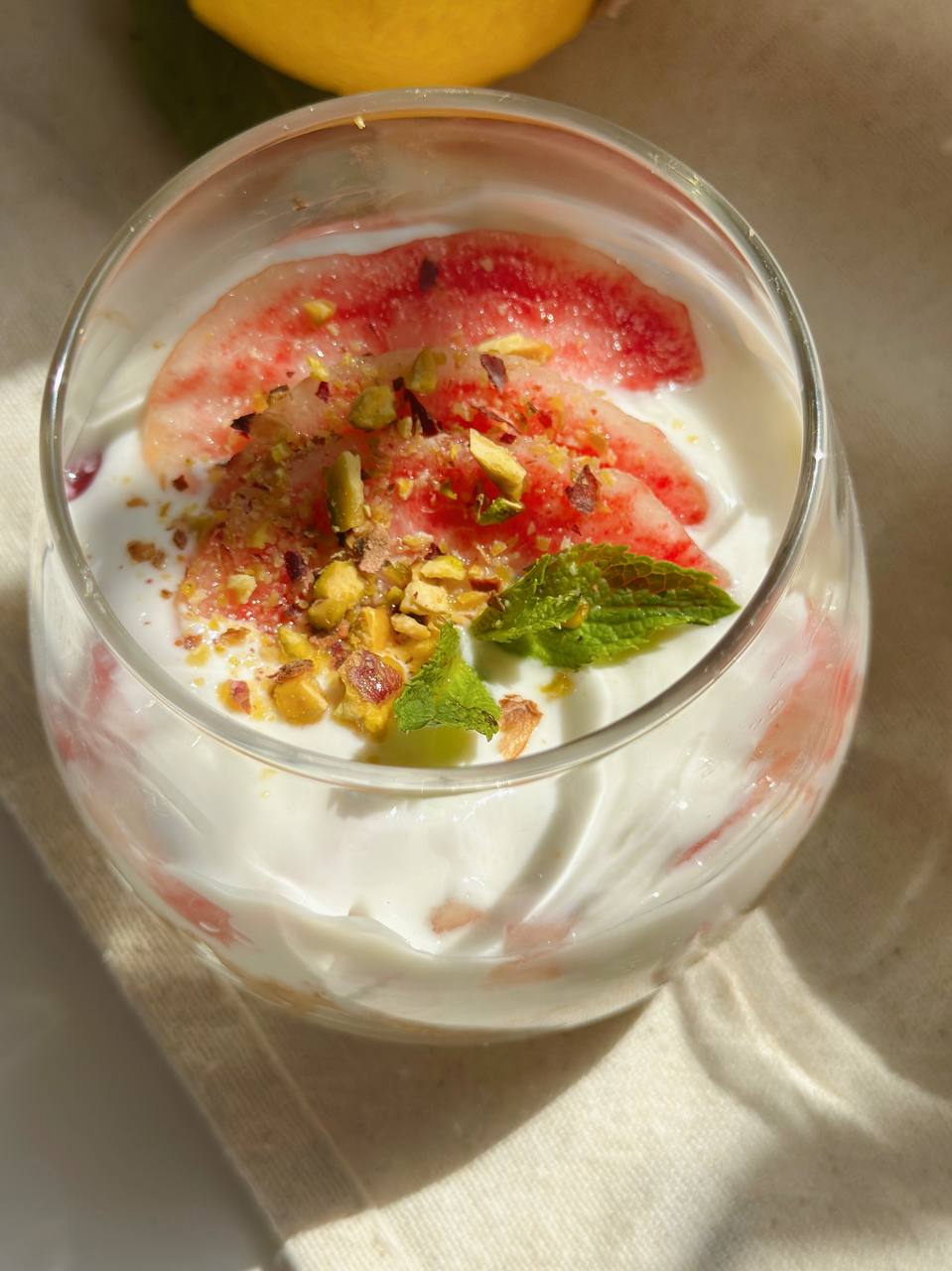 no-bake peach cheesecake cups topped with fresh peaches, pistachios, and mint