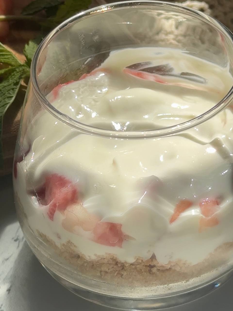 finishing the no-bake peach cheesecake cups with another layer of cream